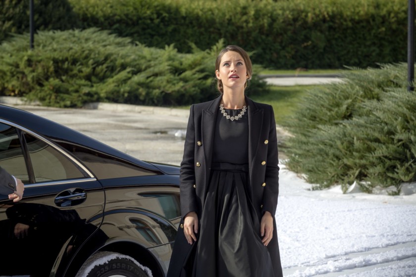 In a still from "A Royal Winter", Maggie stands next to a cab dressed in formal wear, gazing in awe at something off camera. 