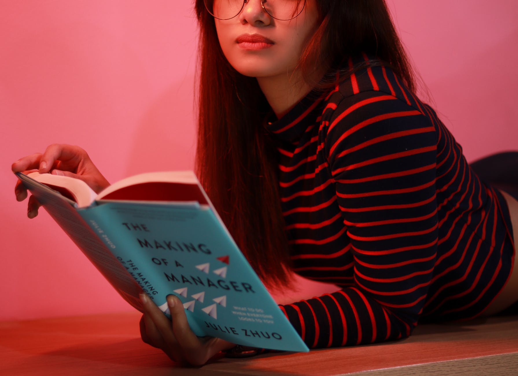 Young woman reads a book to further her career.